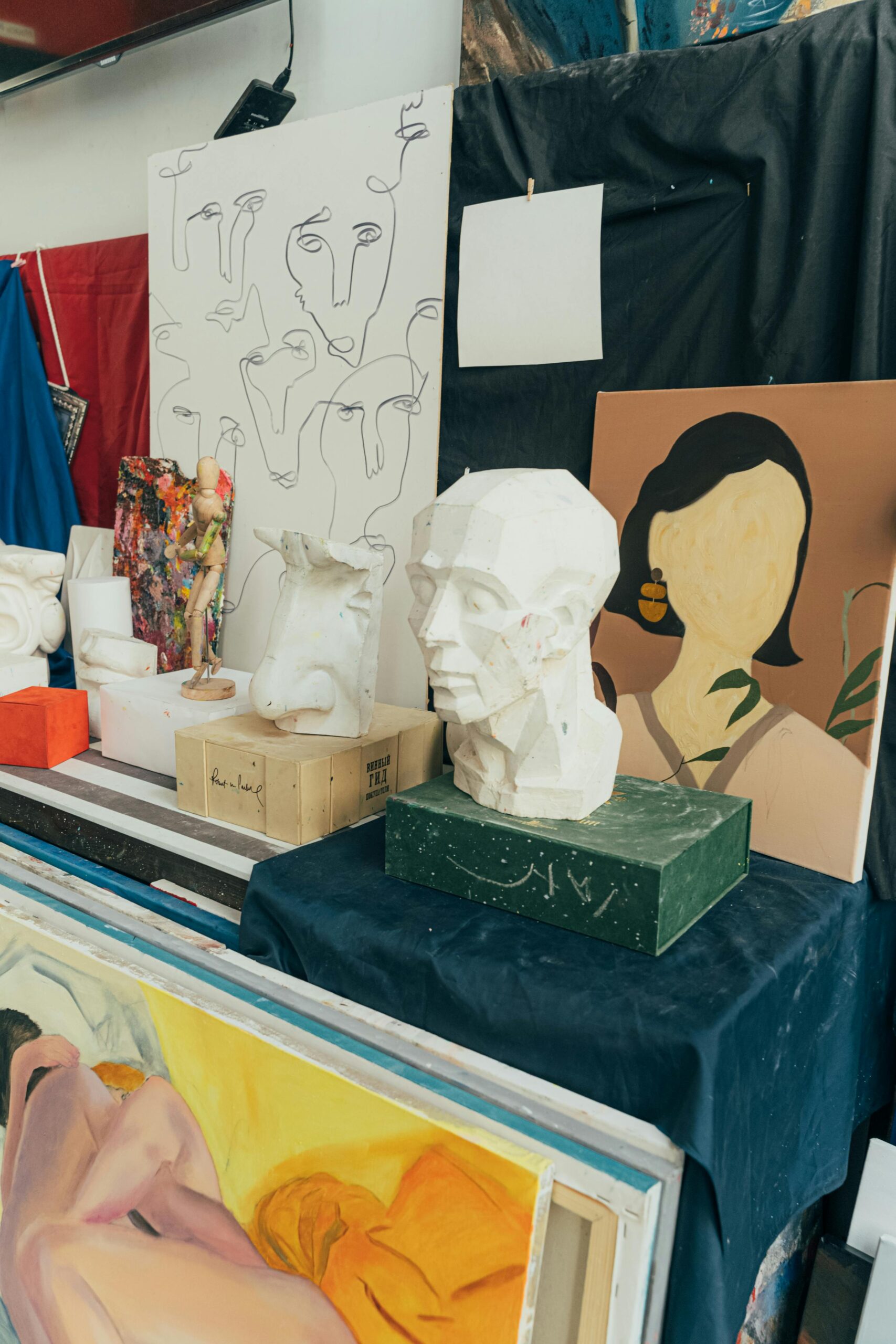 Explore a vibrant art studio featuring diverse sculptures and paintings in a creative setting.