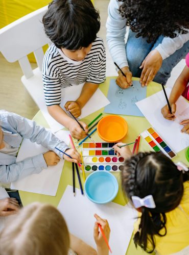 pexels-photo-8612967-8612967 Top view of children painting with watercolors at a preschool art class.